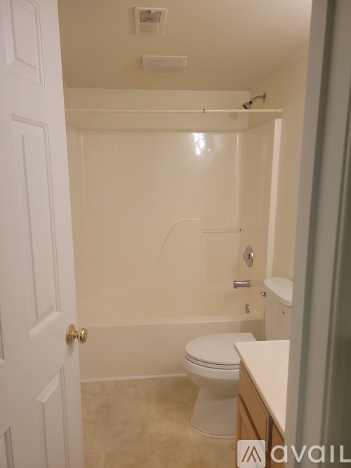 A bathroom with a toilet, tub, and sink.