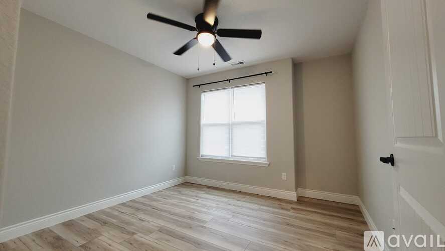 A room with a ceiling fan and a window.