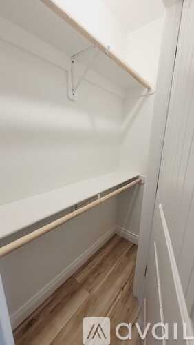 A white closet with a shelf and a hanger.