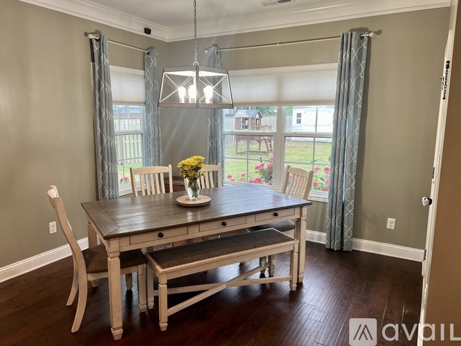 A dining room with a wooden table and chairs.