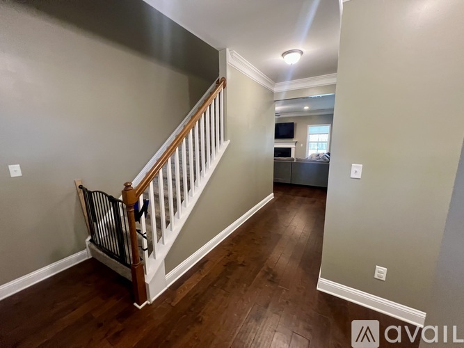 A staircase with wooden handrail and white balusters leads to a bedroom.