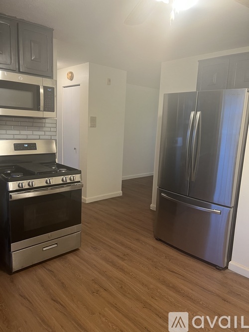 A kitchen with a stove, microwave, and refrigerator.