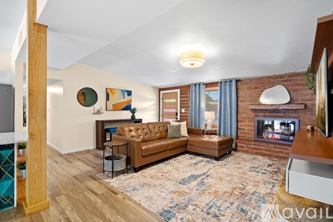 A living room with a brown couch and a fireplace.