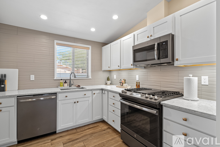 A kitchen with white cabinets and a black stove top oven.