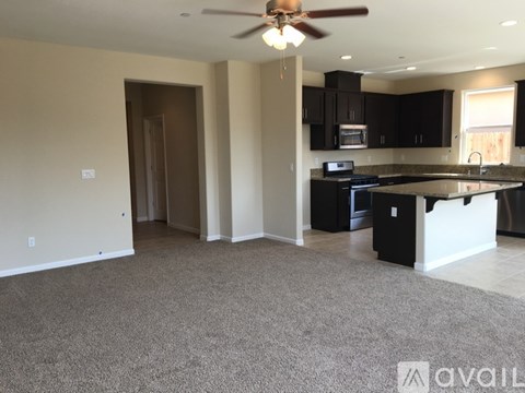 A spacious living room with a kitchen in the background.