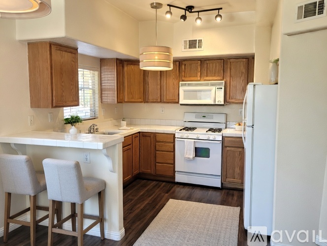 A kitchen with wooden cabinets and white appliances.