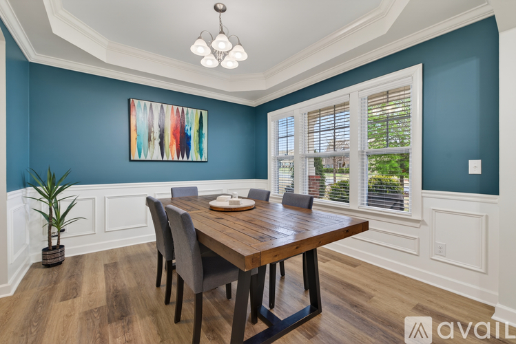 A dining room with a wooden table and chairs.