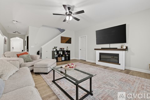 A living room with a grey couch and a glass coffee table.