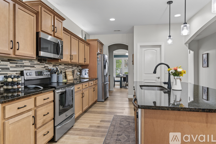 A kitchen with wooden cabinets and a black countertop.