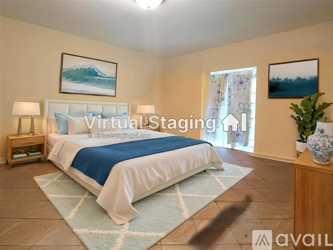 A bedroom with a large bed and a painting of a wave on the wall.