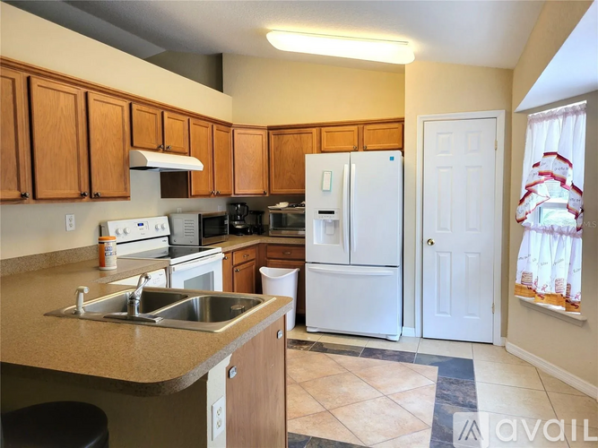 A kitchen with wooden cabinets and a white refrigerator.