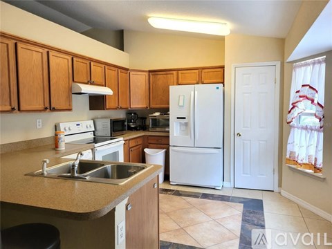 A kitchen with wooden cabinets and a white refrigerator.