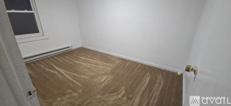 A room with a wooden floor and a window.