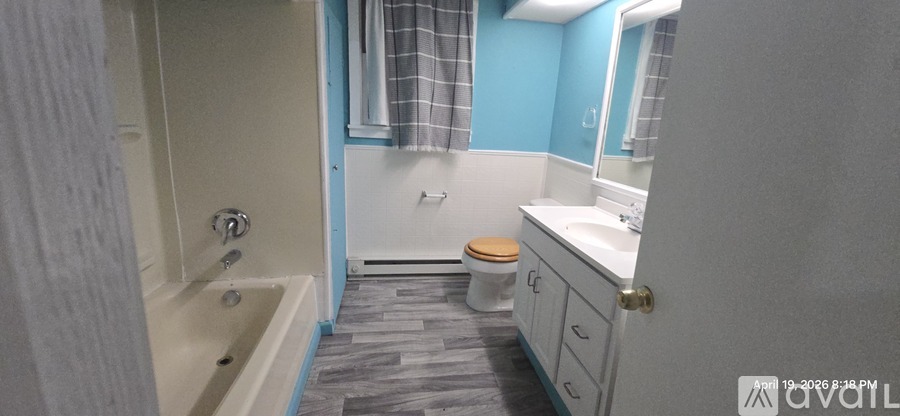 A bathroom with a toilet, sink, and bathtub.