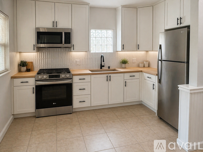 A kitchen with white cabinets and a stainless steel refrigerator.