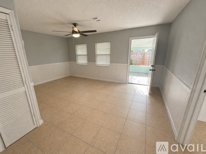A room with a ceiling fan and tiled floor.