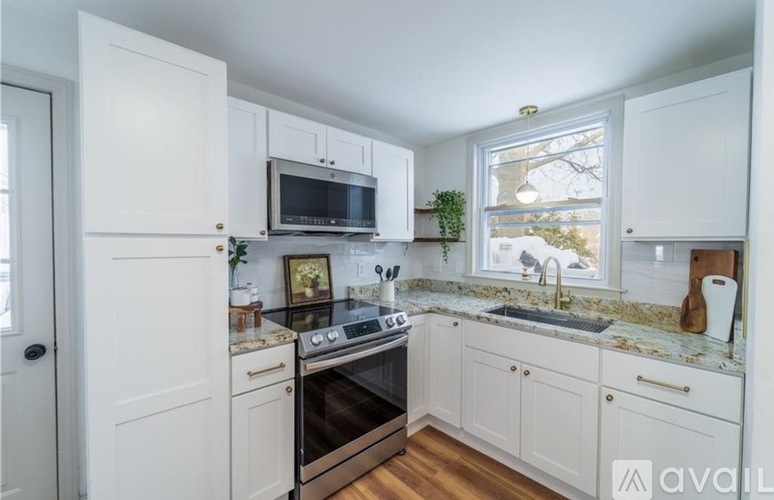 A kitchen with white cabinets and a black stove top oven.