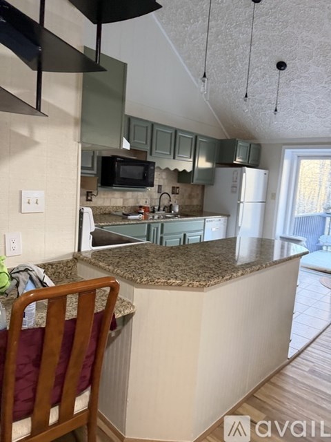 A kitchen with granite countertops and a refrigerator.