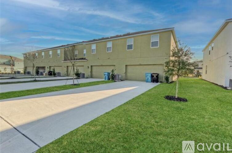 A building with a grassy area in front and a tree planted in the ground.
