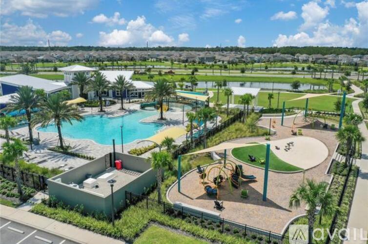 A large outdoor recreational area with a swimming pool, playground, and palm trees.