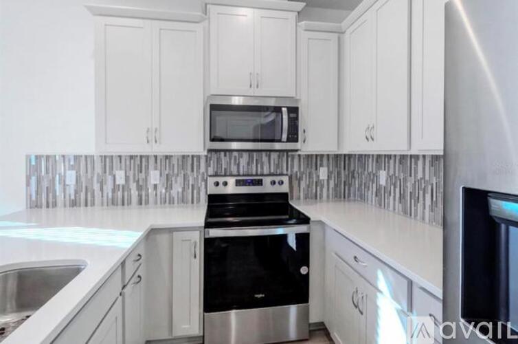A kitchen with white cabinets and a black stove top oven.