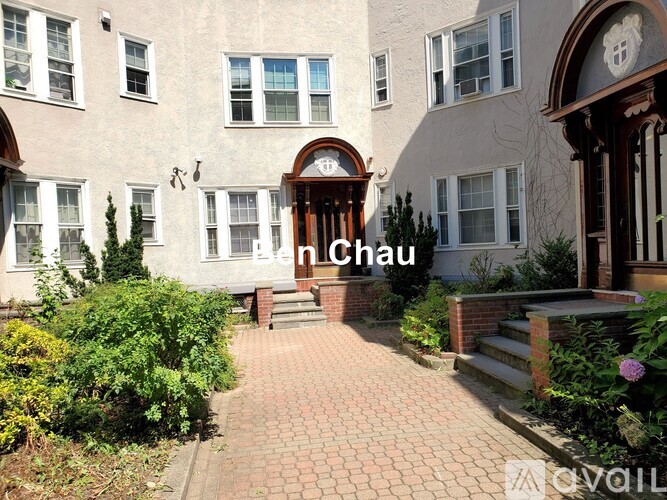 A building with a brick pathway leading to a door with a sign that says "n Chau".