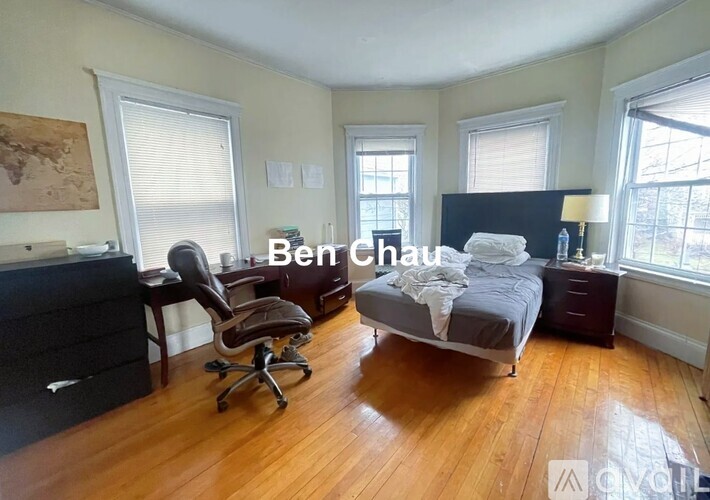 A bedroom with a bed, desk, and chair.
