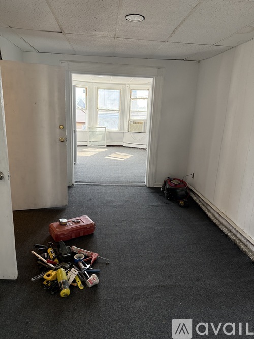 A room with a white door and a window with a view of a building outside.