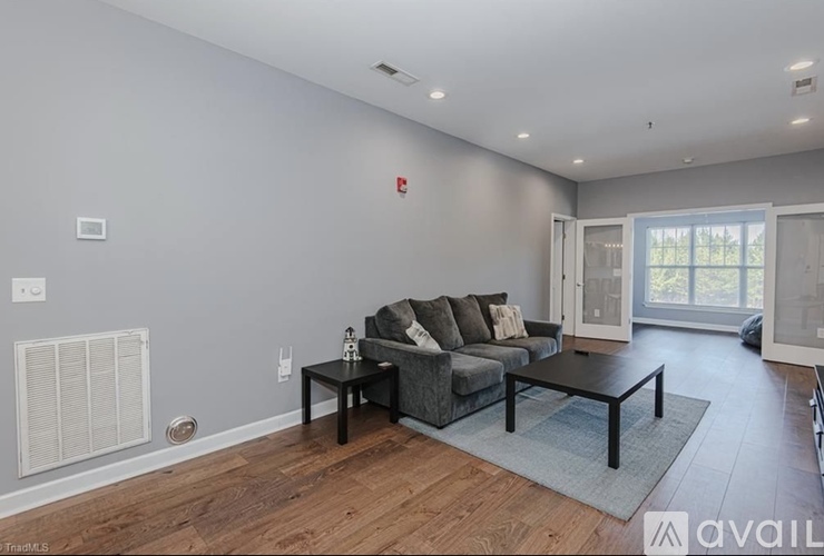 A living room with a grey couch and a black coffee table.