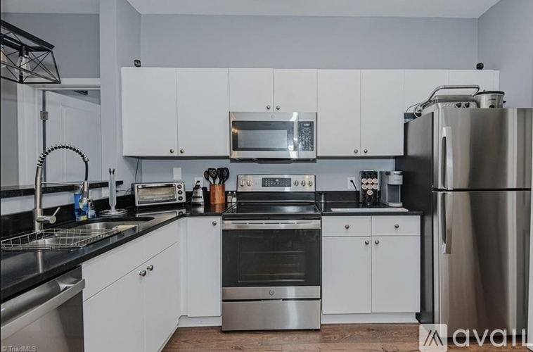 A kitchen with white cabinets and stainless steel appliances.