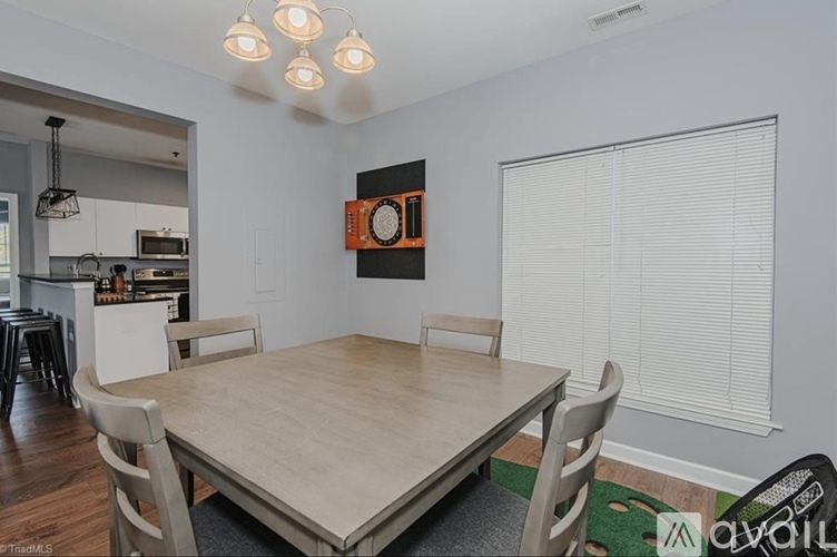 A dining room with a wooden table and chairs.