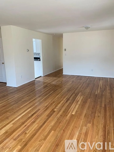 A room with wooden flooring and white walls.