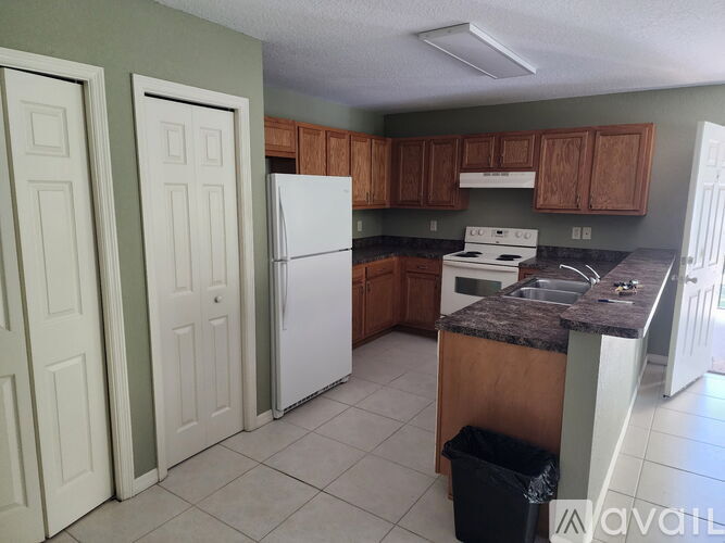 A kitchen with white appliances and brown cabinets.