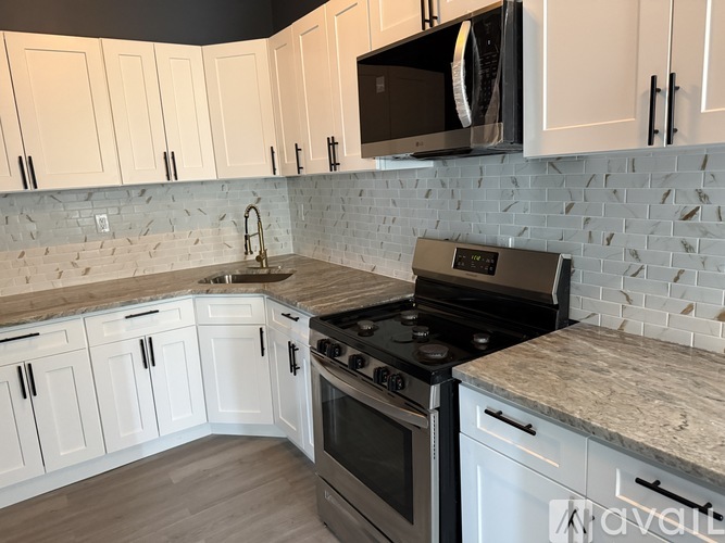 A kitchen with white cabinets and a black stove top oven.
