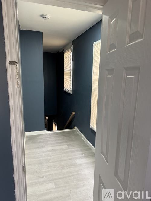 A white door is open to a room with blue walls.