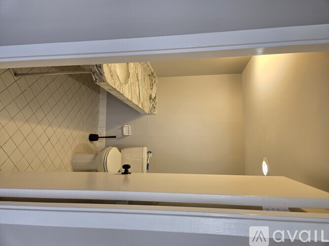 A bathroom with a white counter and a tiled wall.