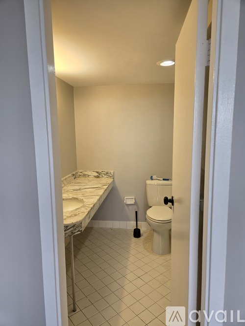 A small bedroom with a bed, toilet and sink.