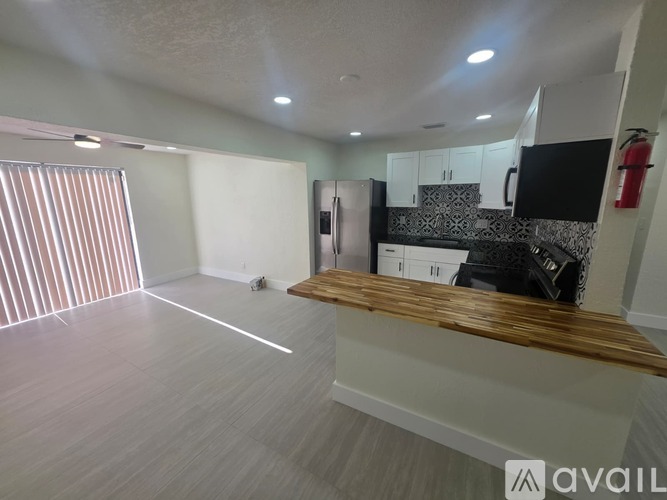 A spacious kitchen with a refrigerator, cabinets, and a countertop.