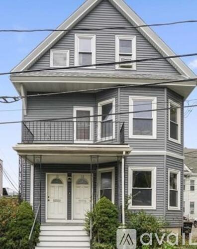 A two-story house with a balcony on the second floor.