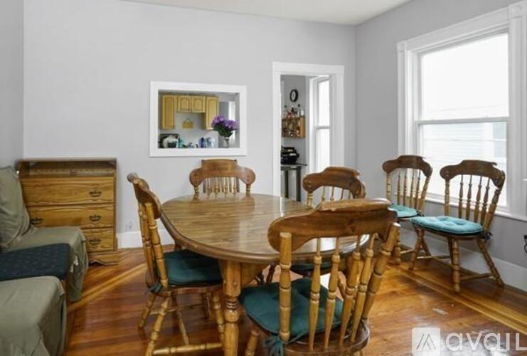 A dining room with a wooden table and chairs.