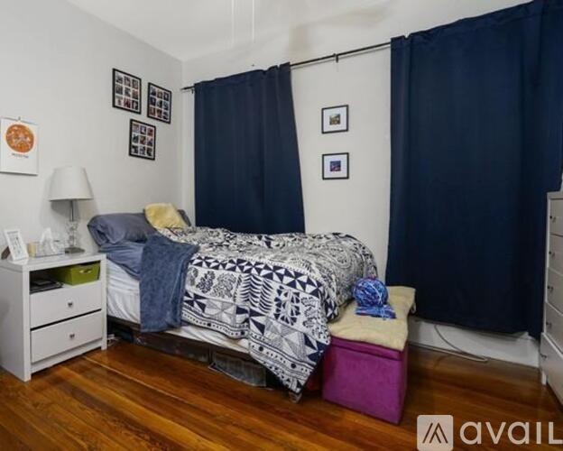 A bedroom with a bed, nightstand, and pictures on the wall.