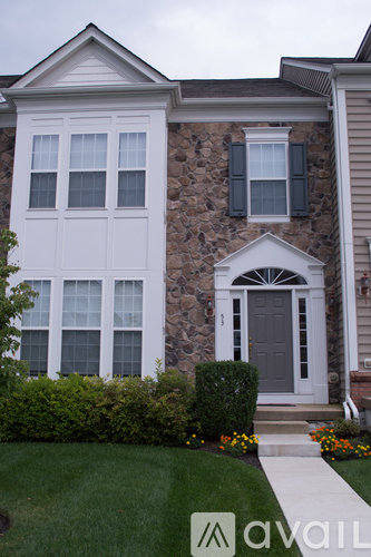 A house with a grey front door and a window with black shutters.