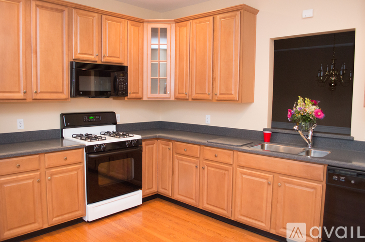 A kitchen with wooden cabinets and a black microwave above the stove.