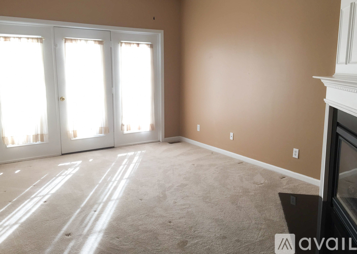 A room with a fireplace and a carpeted floor.