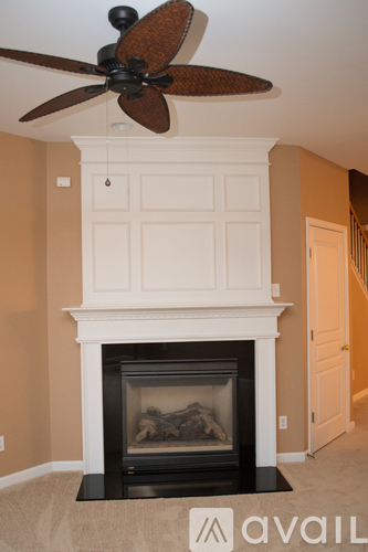A room with a fireplace and a ceiling fan.