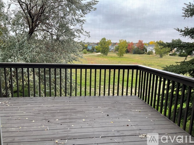 A deck with a railing overlooking a grassy area.