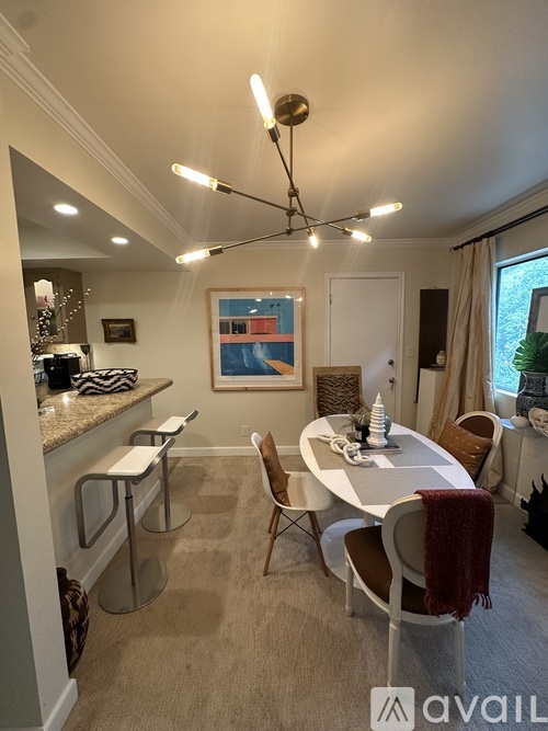 A dining room with a white table and chairs.