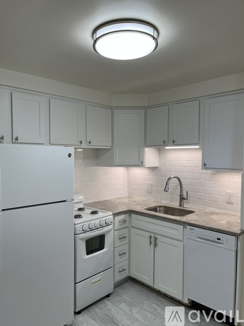 A kitchen with white appliances and cabinets.