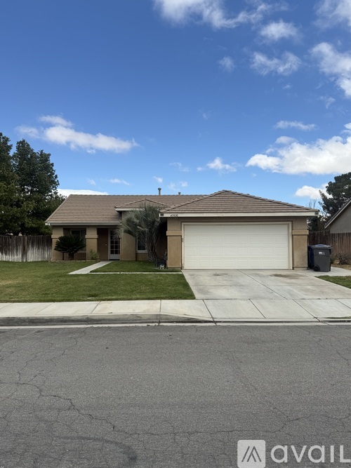 A house with a white garage door is in front of a tree.