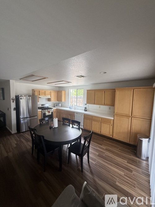 A kitchen with wooden cabinets and a table with chairs.